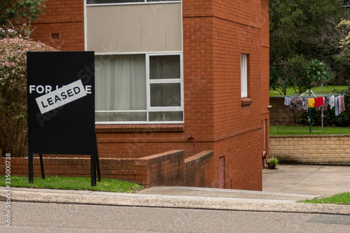 For lease and leased sign on a black display outside of a resedential building photo