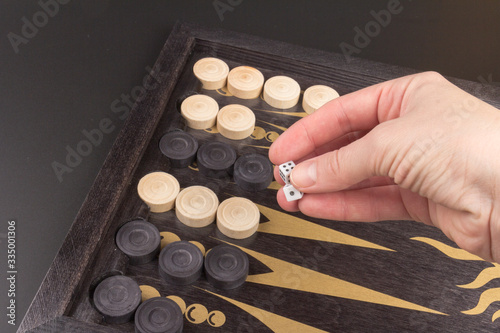 Detail of a backgammon game with two dice close up, on black. Dice on backgammon board game. Selective focus. Playing leisure games photo