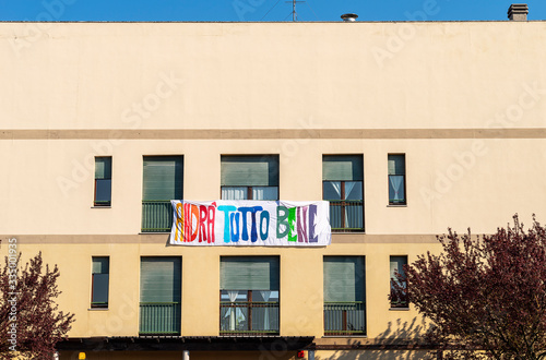 Facade of an house with a banner ‘andrà tutto bene’, italian message of hope in coronavirus times © Marina Zanotti