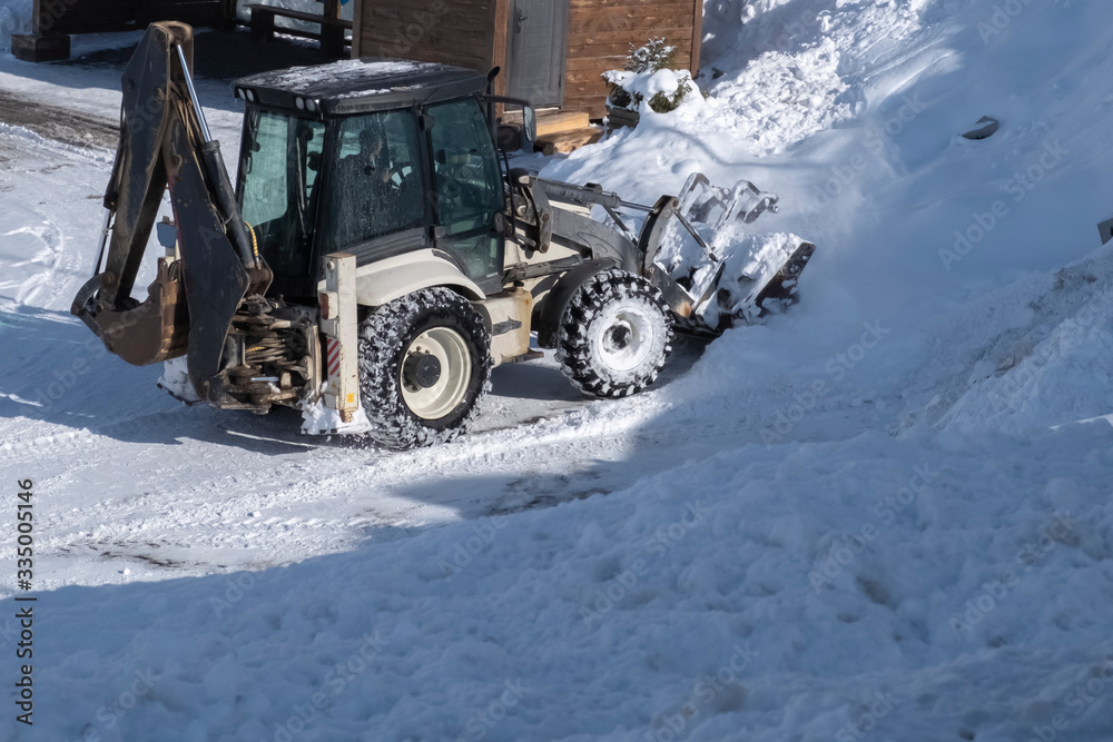 Tractor removing snow after snowfall. Winter season. Snow clearing. Tractor clears the way after heavy snowfall. Tractor removing snow after snowfall. Winter season. Snow clearing. Tractor clears the way after heavy snowfall.