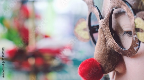 Vászonkép Close up young woman wearing funny Christmas party deer glasses with red nose