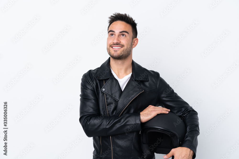 Man with a motorcycle helmet looking up while smiling Man with a motorcycle helmet looking up while smiling