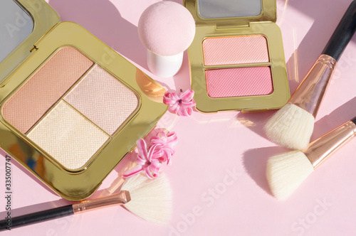 premium makeup brushes, sponge and blush pads on a bright colorful pink and blue background, creative cosmetics flat lay