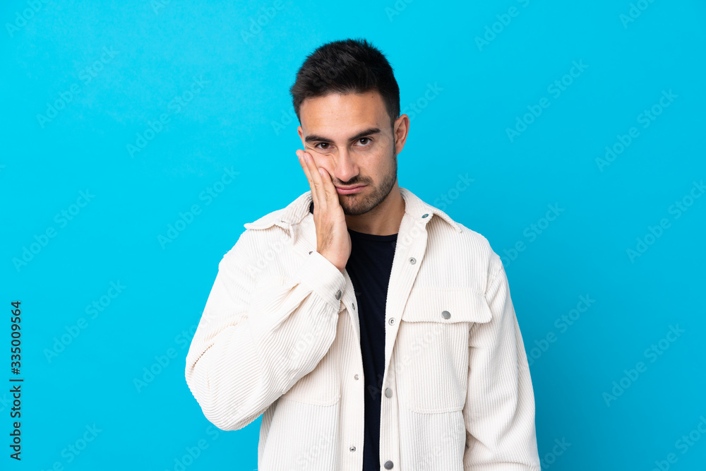 Young handsome man over isolated blue background unhappy and frustrated Young handsome man over isolated blue background unhappy and frustrated