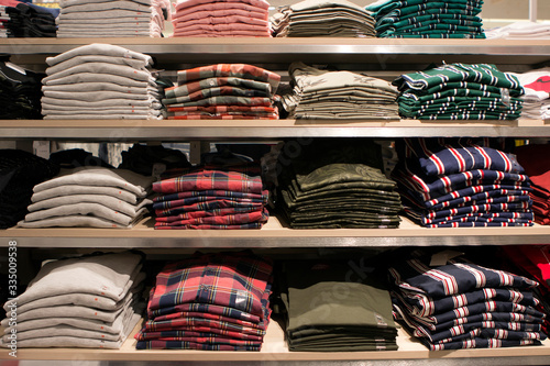 many folded plaid shirts lie on store shelves
