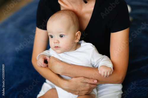 Caucasian baby 6 months in the arms of mom