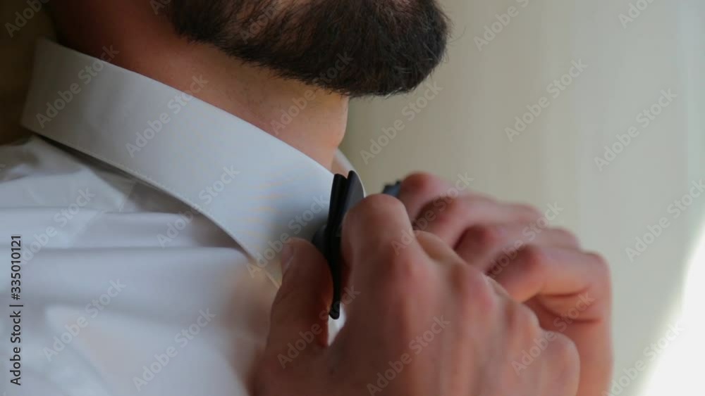 Close-up hands of businessman with expensive watches buttons cuff link on French cuffs sleeves luxury white shirt. The groom is preparing for the wedding, going to meet with the bride Close-up hands of businessman with expensive watches buttons cuff link on French cuffs sleeves luxury white shirt. The groom is preparing for the wedding, going to meet with the bride