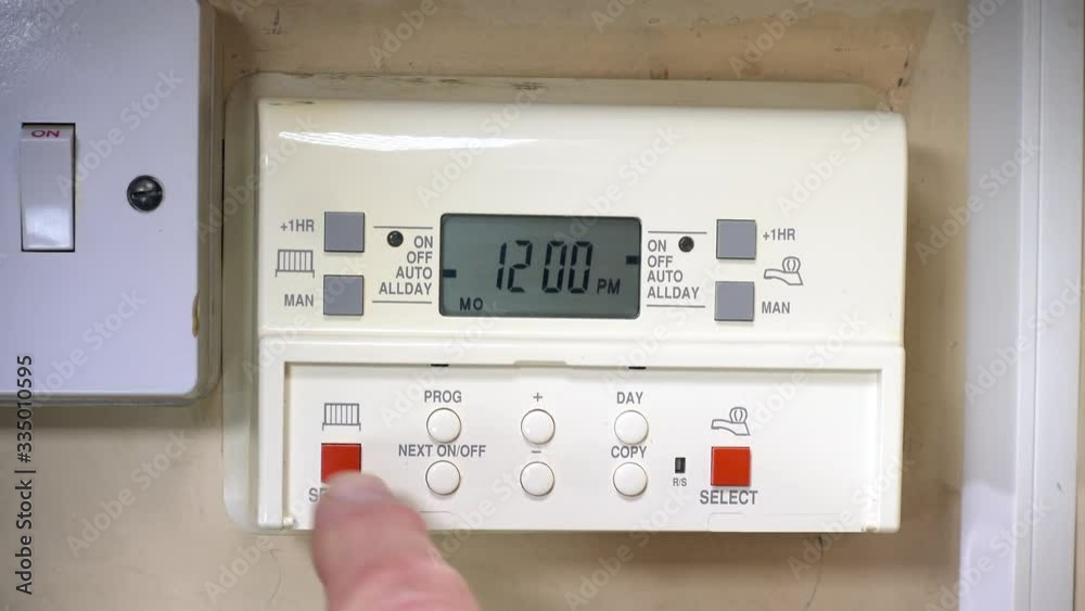 Close POV shot of a finger switching on the electricity supply, then pressing the buttons to activate the central heating and hot water on an old programmer / timer. Close POV shot of a finger switching on the electricity supply, then pressing the buttons to activate the central heating and hot water on an old programmer / timer.
