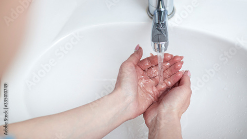 washing hands at bathroom sink man hand hygiene for corona virus pandemic precaution by washing hands frequently for 30 seconds photo