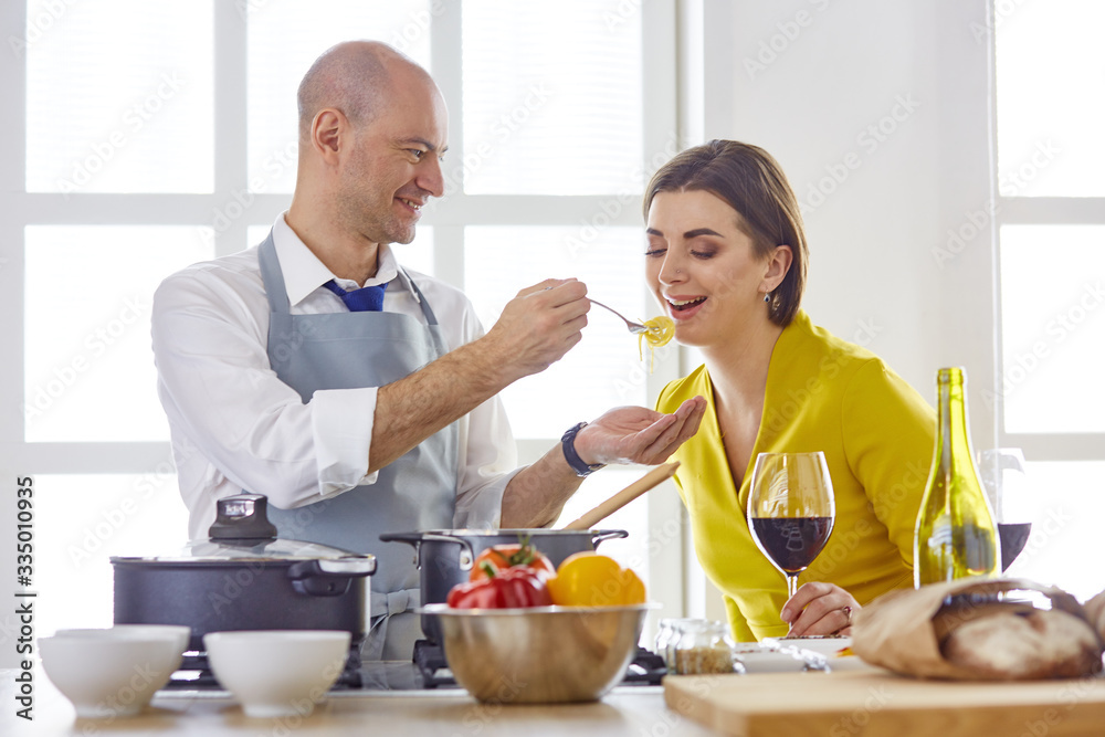 Smiling young couple cooking food in the kitchen Smiling young couple cooking food in the kitchen