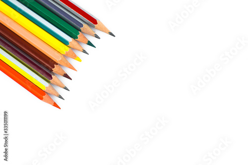 Single row of different colored wood pencil crayons arranged together in a line format