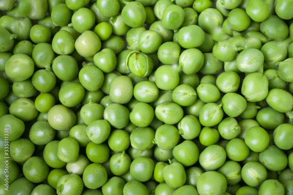 Green pea closeup macro. Horizontal photo of peeled peas on the market bench / counter / stand. Vegetable of summer season. Green pea closeup macro. Horizontal photo of peeled peas on the market bench / counter / stand. Vegetable of summer season.