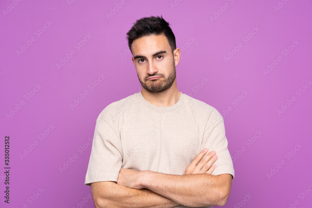 Obraz premium Young handsome man over isolated purple background feeling upset