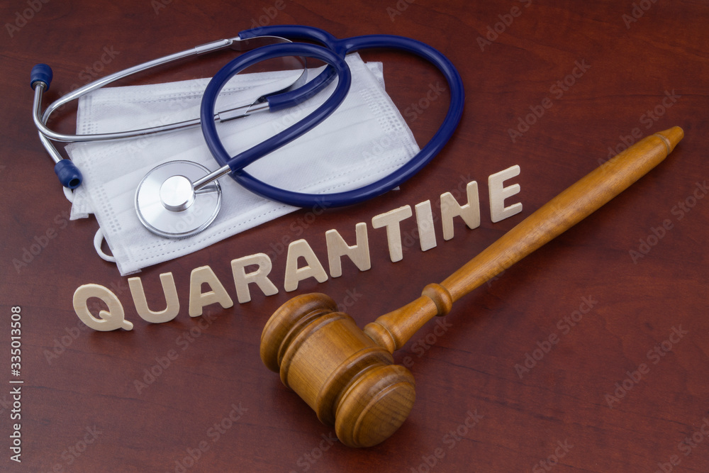 Wooden judge gavel, masks with stethoscope and word quarantine. Law and quarantine concept. Wooden judge gavel, masks with stethoscope and word quarantine. Law and quarantine concept.