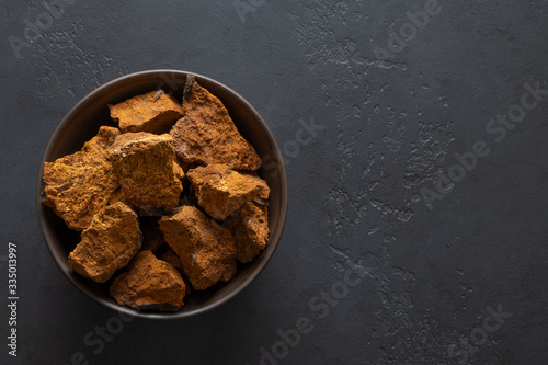 Schilderij op canvas Chaga Birch Mushrooms in bowl on black table