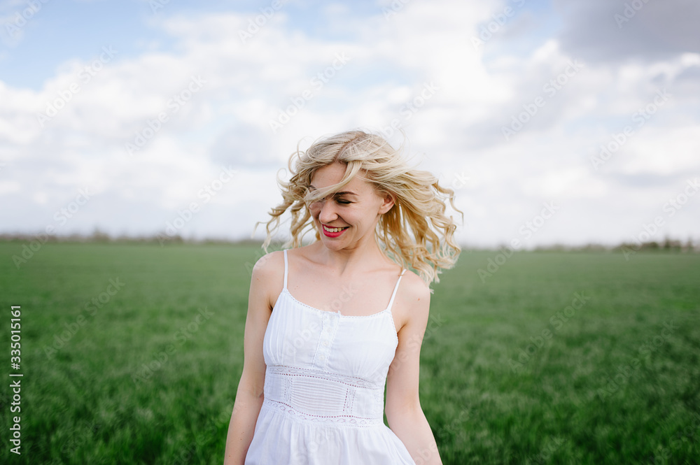 Family on a walk in a field with green grass and blue sky, early spring, good weather, happy family, white clothes Family on a walk in a field with green grass and blue sky, early spring, good weather, happy family, white clothes