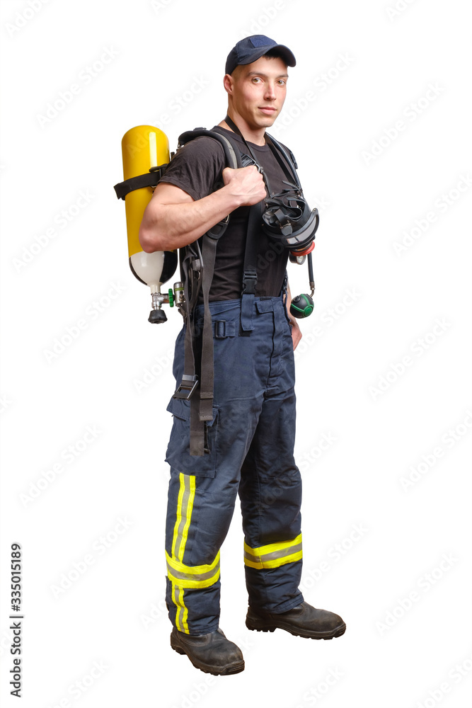 Young fireman in baseball cap with respirator and air breathing apparatus on his back Young fireman in baseball cap with respirator and air breathing apparatus on his back