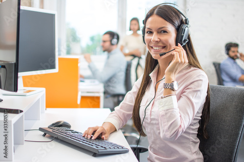 Fotografi Friendly female helpline operator with headphones in call center