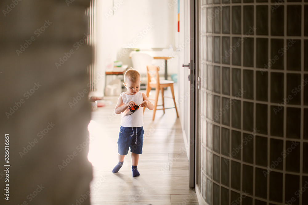 Caucasian child with tape measure wall in house
