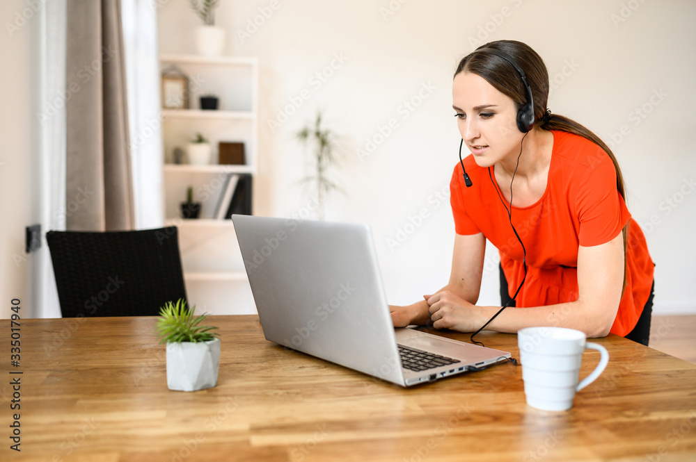 Woman works from home using headset and laptop Woman works from home using headset and laptop