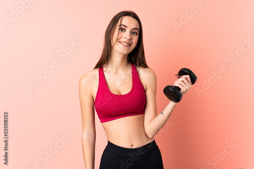 Young sport woman making weightlifting over isolated pink background with happy expression © luismolinero