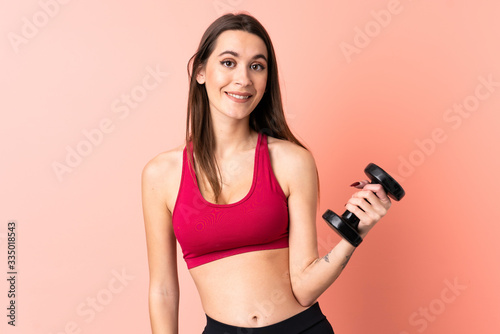 Young sport woman making weightlifting over isolated pink background with happy expression