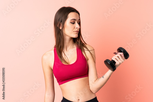 Young sport woman making weightlifting over isolated pink background with happy expression