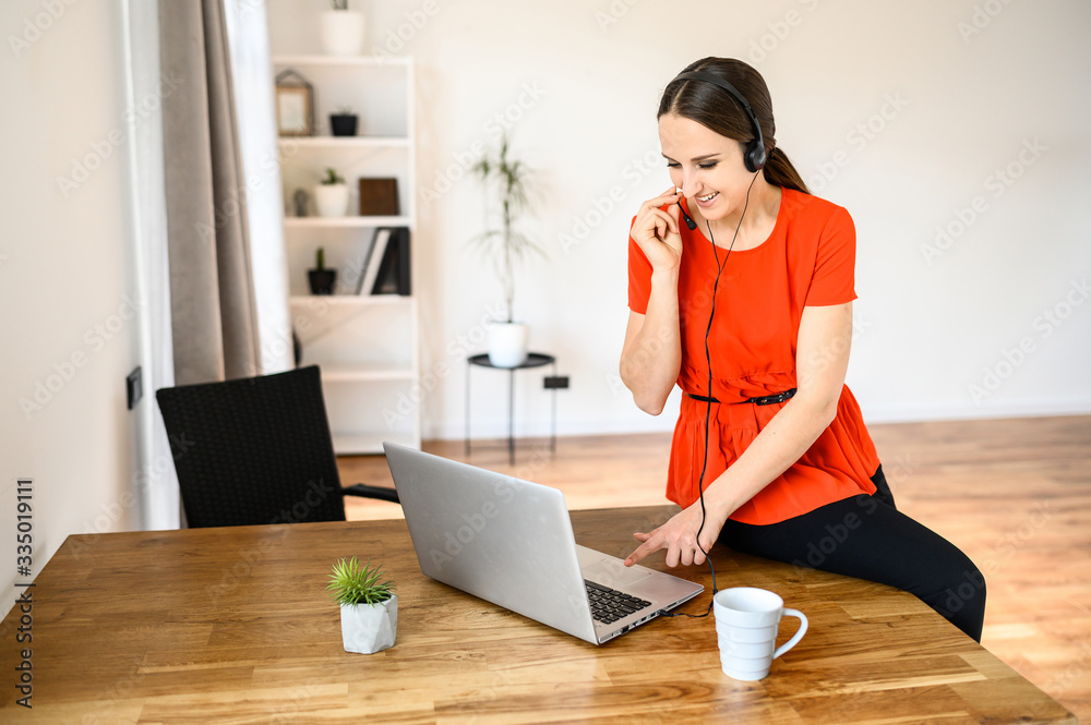 Woman works from home using headset and laptop Woman works from home using headset and laptop