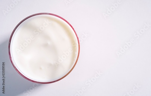 Macro plan organically pure gluten-free dairy product. Smooth yoghurt surface in a transparent glass glass close-up on a white background, isolated