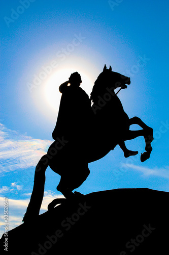 Real photo of shade silhouette Bronze horseman monument with a bright sun behind the head. (ID: 335020547)