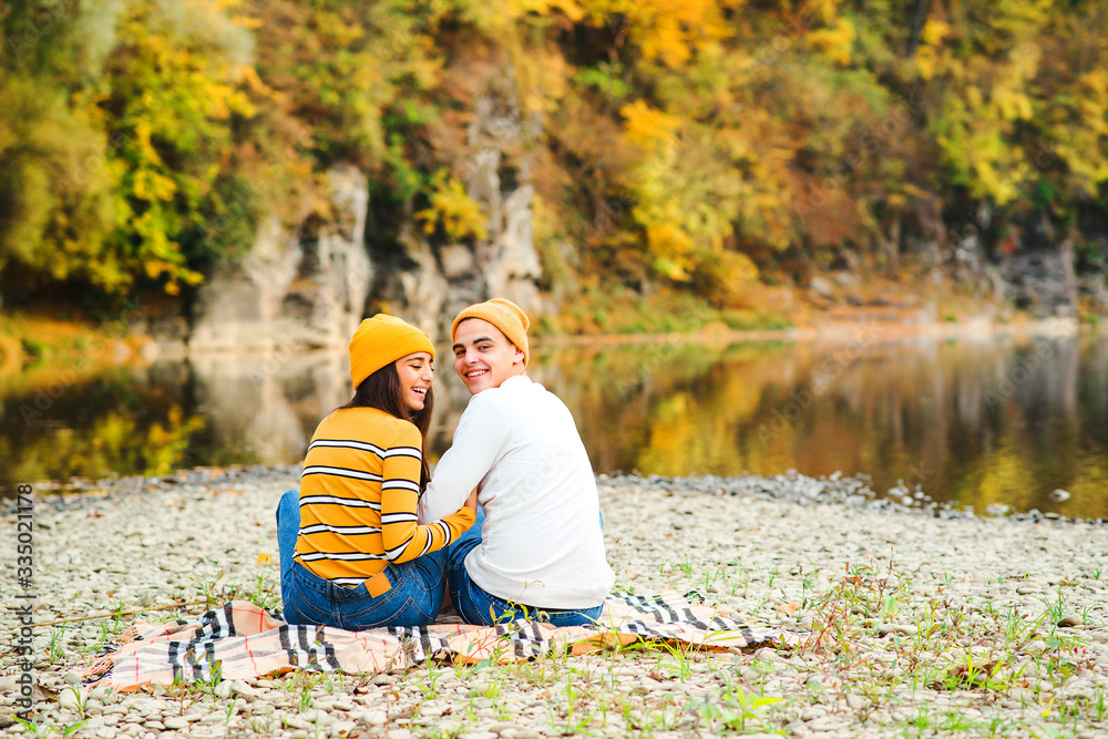 Boyfriend with girlfriend on a walk near lake in autumn. Fashion couple, lifestyle and love. Couple in love in autumn nature. Boyfriend with girlfriend on a walk near lake in autumn. Fashion couple, lifestyle and love. Couple in love in autumn nature.