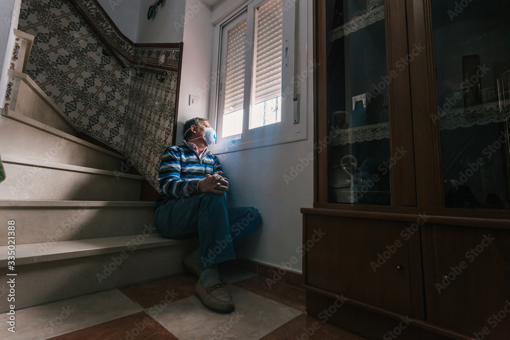 Selective focus of man with a mask confined in quarantine to prevent coronavirus spread to the window. Selective focus of man with a mask confined in quarantine to prevent coronavirus spread to the window.