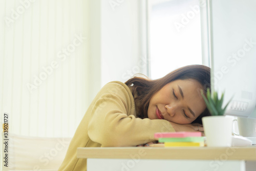 close up young employee woman sleeping at desktop table after feeling asleep in the afternoon for work from home and quarantine time concept