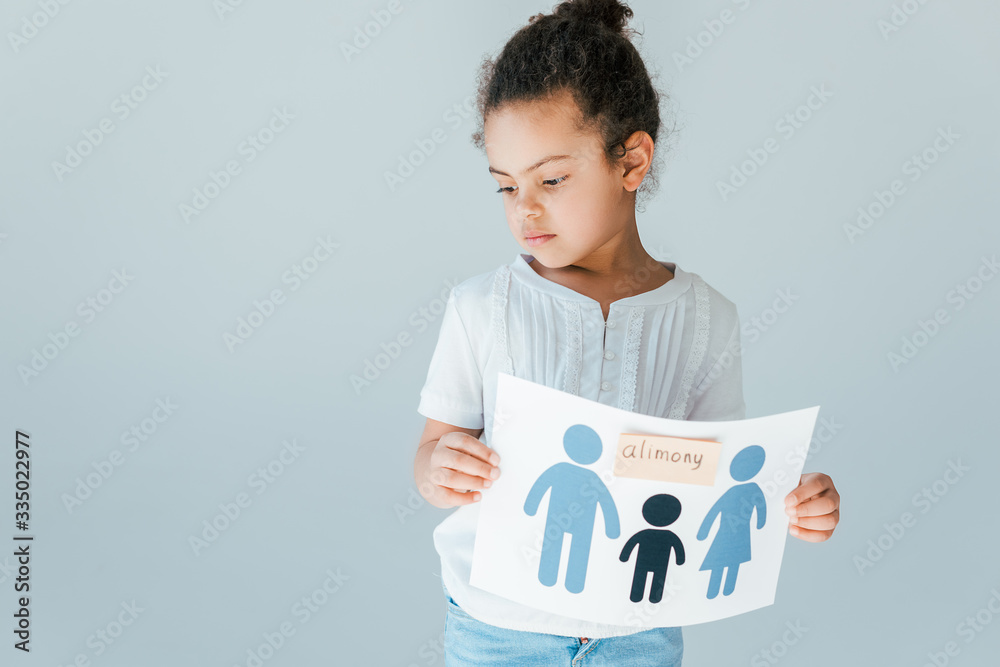 upset african american child holding paper with drawn family and alimony lettering isolated on white upset african american child holding paper with drawn family and alimony lettering isolated on white