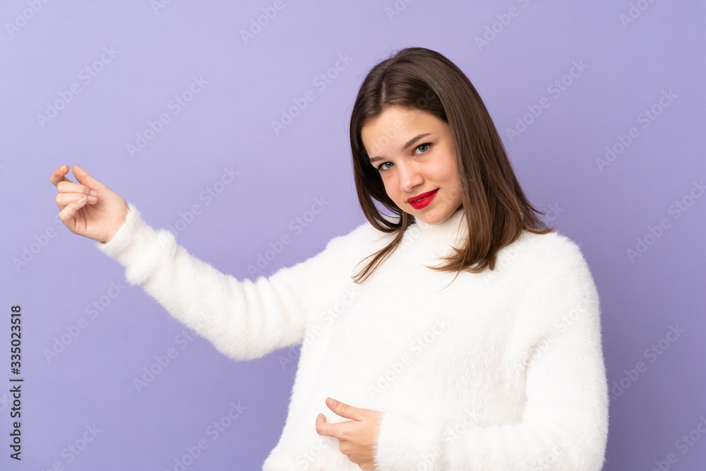 Teenager girl isolated on purple background making guitar gesture Teenager girl isolated on purple background making guitar gesture