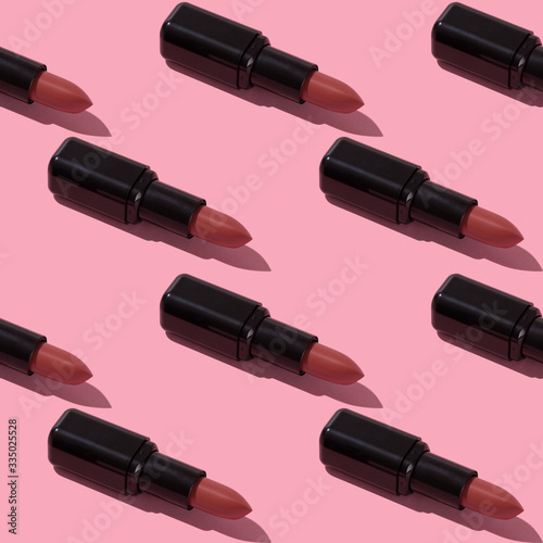 Seamless nude lipstick pattern on pink background.