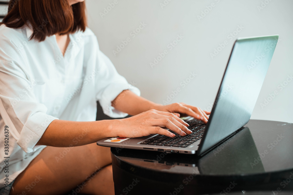 young woman working on laptop computer while sitting at the living room. work from home concept young woman working on laptop computer while sitting at the living room. work from home concept