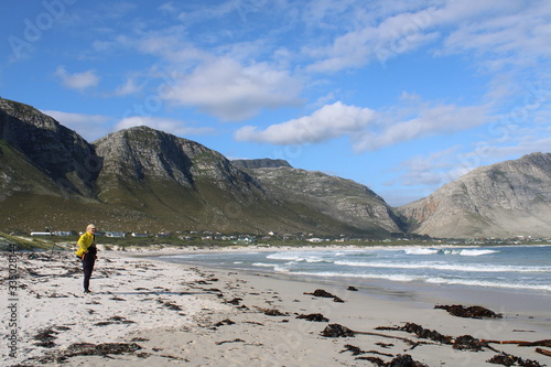 man on the beach with yellow fishing jacket