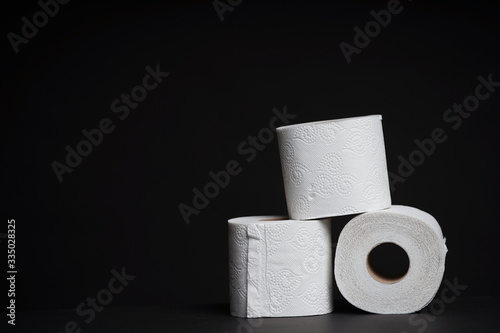 Toilet paper rolls on a black background. Cheap toilet wipes for hygiene purposes.