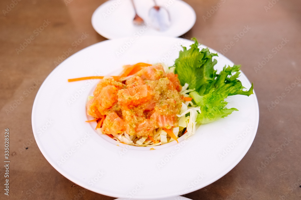 Salmon spicy salad thai style on the white dish Salmon spicy salad thai style on the white dish