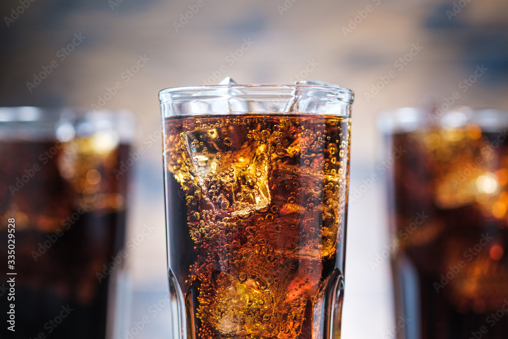 Closeup cola with bubbles and ice cubes. Cold fizzy drink Closeup cola with bubbles and ice cubes. Cold fizzy drink