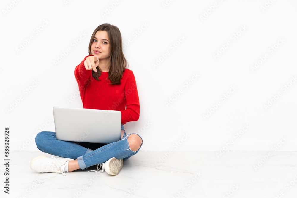 Tenaager girl working with pc isolated on white background points finger at you with a confident expression