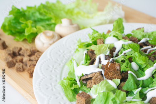 Vegetarian version of classic Caesar salad with mushrooms instead of chicken, croutons, lettuce, parmesan cheese and dressing sauce