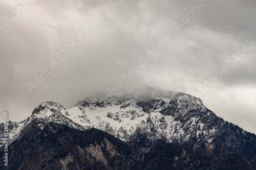 misty mountain moody landscape scenic view winter lonely peak with slightly snow cover and gray cloudy sky