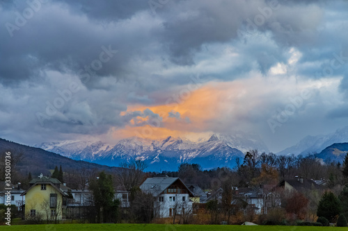 twilight depressive Europe village landmark park outdoor scenic view with Alps mountain background and beautiful dramatic cloudy sky and evening sunset lighting
