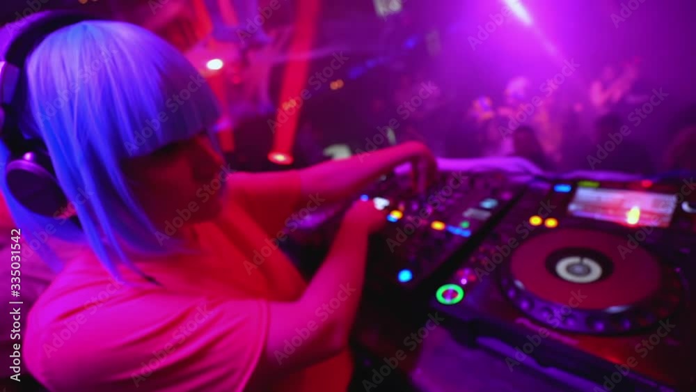 Professional female dj working at mixer in the night club, electronic music