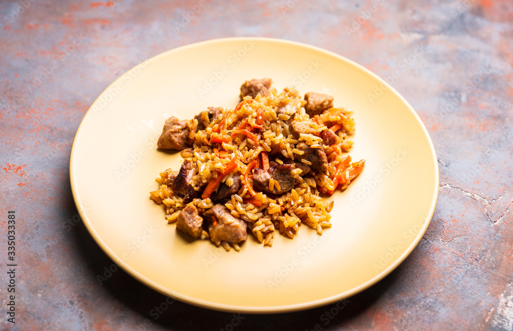 Traditional Uzbekistan pilaf on the rustic background. Selective focus. Shallow depth of field. Traditional Uzbekistan pilaf on the rustic background. Selective focus. Shallow depth of field.