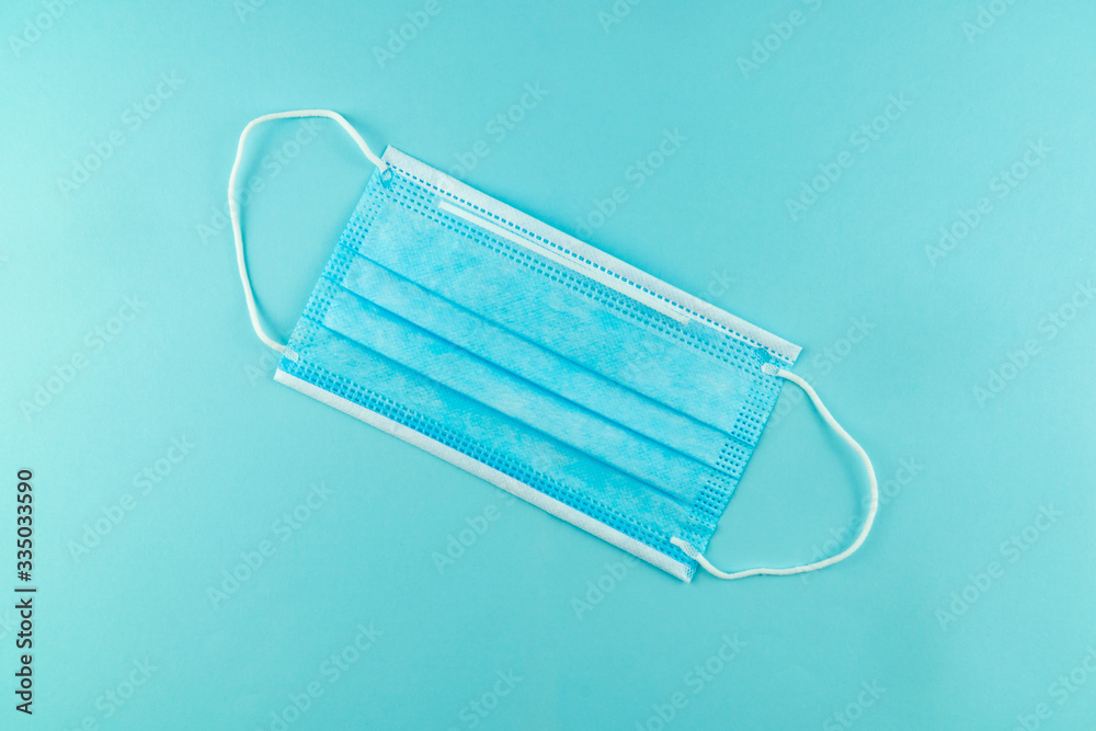3 ply surgical face mask isolated on light blue background. 3 ply surgical face mask isolated on light blue background.