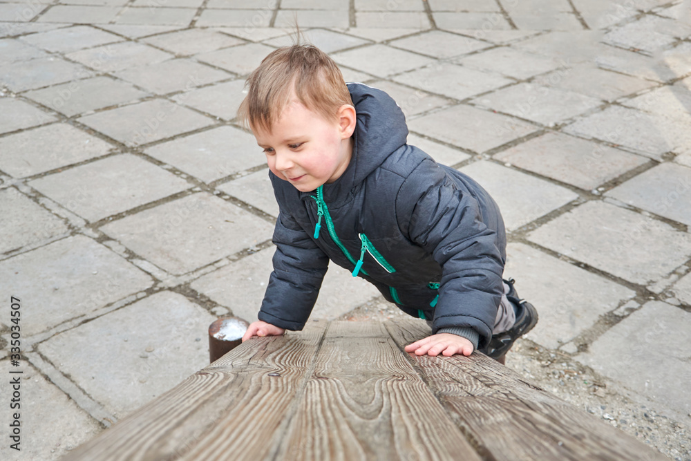 little boy is climbing on a wooden board. little boy is climbing on a wooden board.