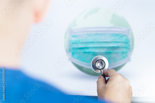 Asian mmale doctor using stethoscope listening to world, save world from covid-19, Corona virus concept photo